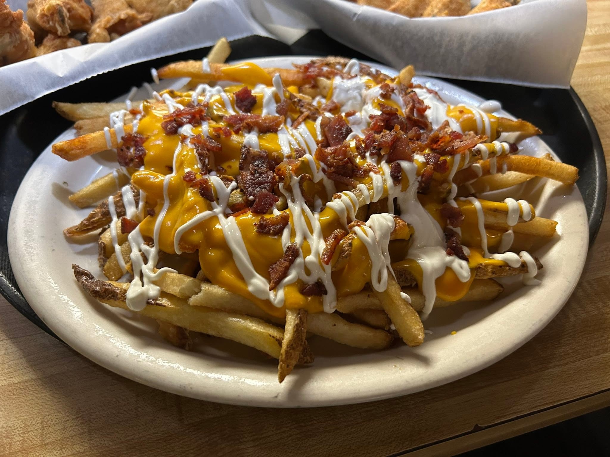 Handmade loaded fries topped with melted cheese and bacon