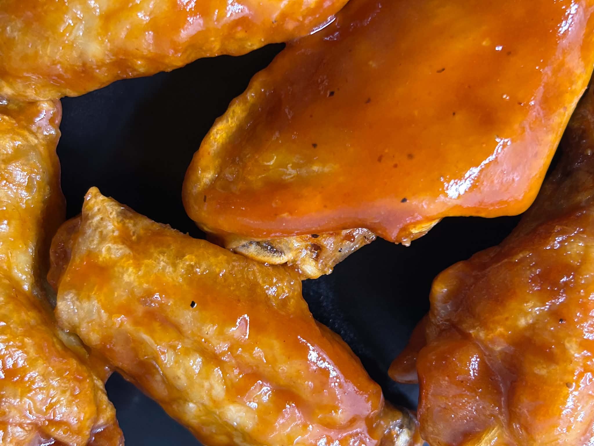 Close-up of chicken wings coated in sauce